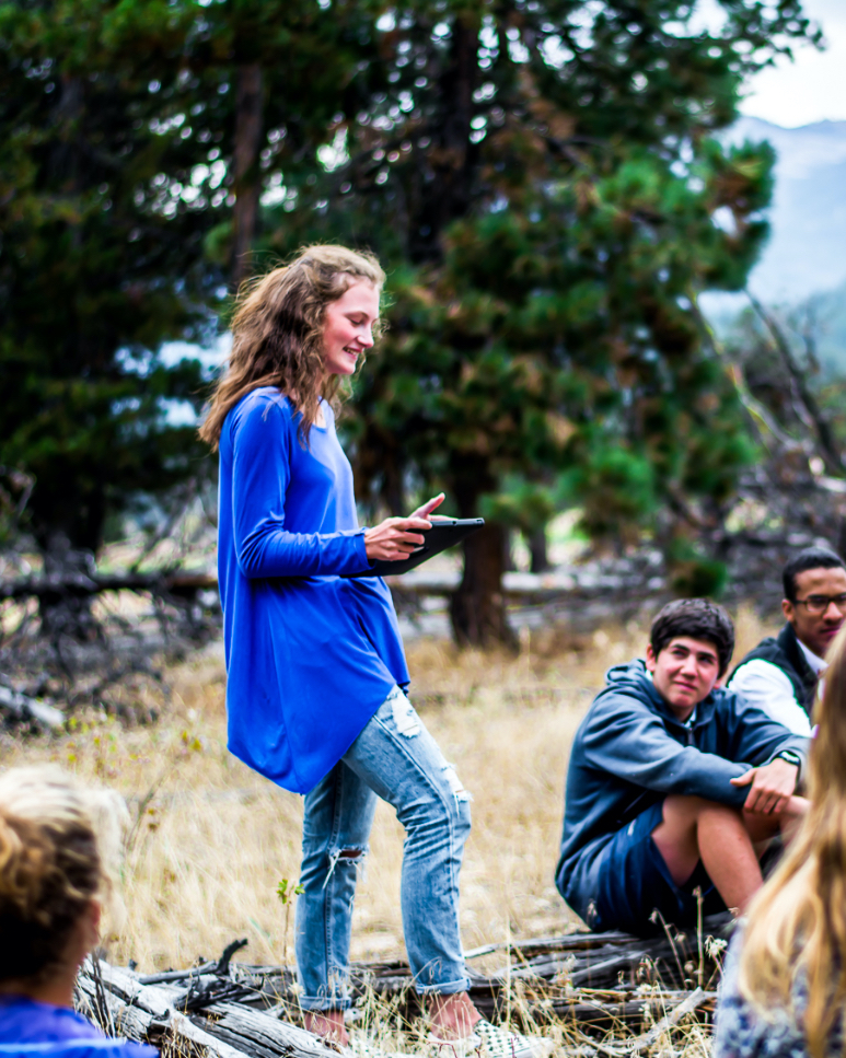 student speaking at a campfire