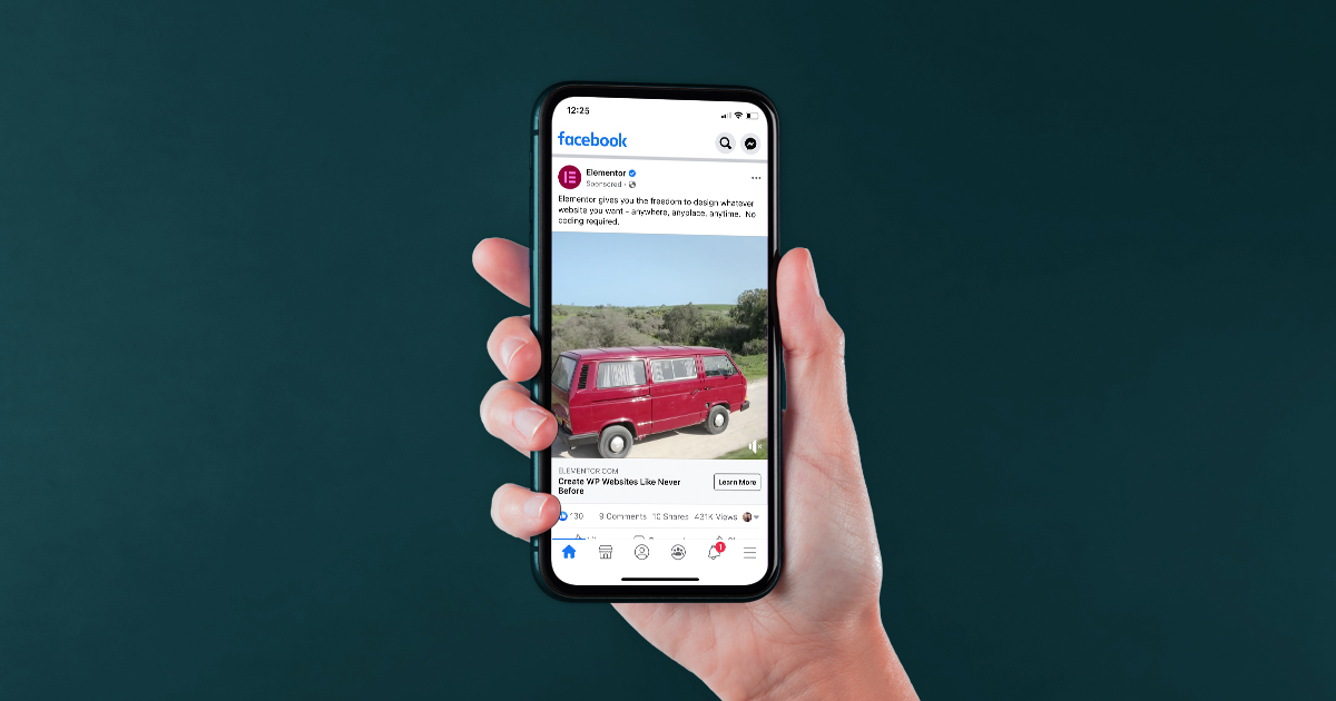 On a dark green background, a hand holds a phone toward the camera. On the phone is an example of a Facebook ad. The ad depicts a red van driving down a dirt road.