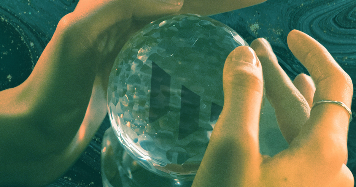 Rectangular image. Hands around a crystal ball. The crystal ball has a subtle W in the center. There is a subtle, swirly, green texture in the background of the image.